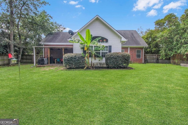 rear view of property with a yard