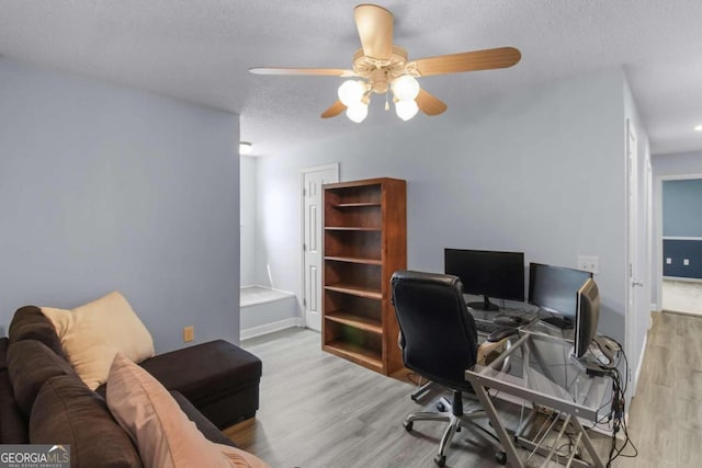 office area featuring ceiling fan, a textured ceiling, and light hardwood / wood-style flooring