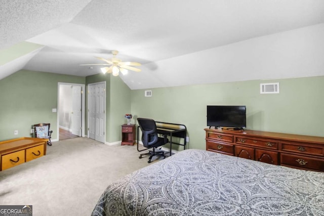 bedroom with vaulted ceiling, light carpet, a textured ceiling, and ceiling fan