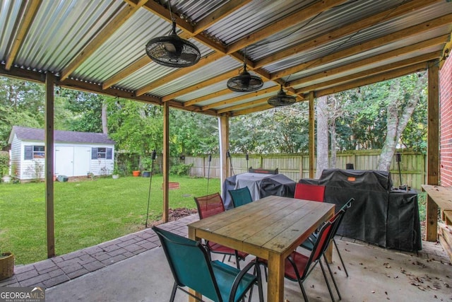 view of patio featuring a shed, ceiling fan, and grilling area