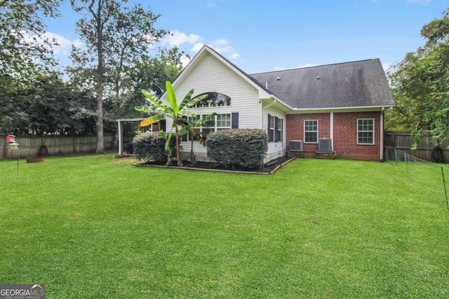 back of property with cooling unit and a lawn