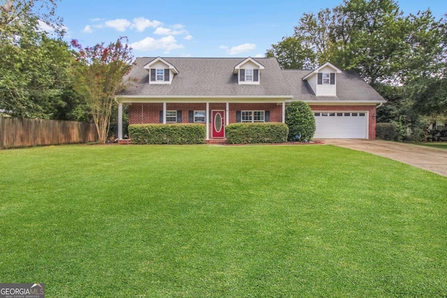 cape cod house featuring a garage and a front lawn