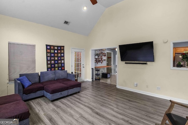 living room featuring hardwood / wood-style flooring, high vaulted ceiling, and ceiling fan