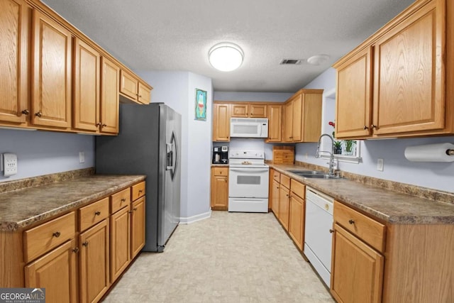 kitchen with white appliances, a textured ceiling, and sink