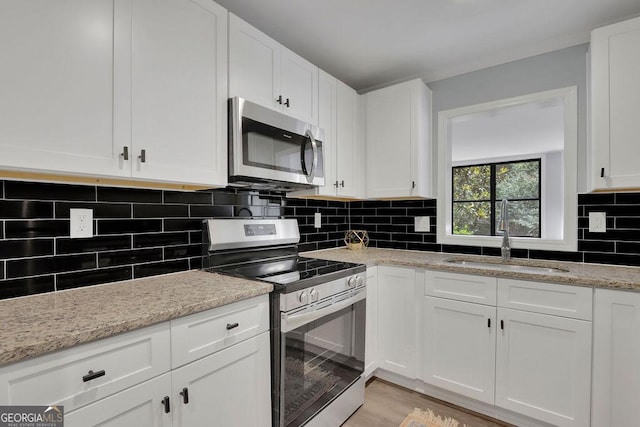 kitchen featuring sink, white cabinetry, appliances with stainless steel finishes, and tasteful backsplash