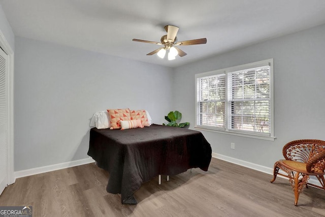 bedroom with hardwood / wood-style floors, a closet, and ceiling fan