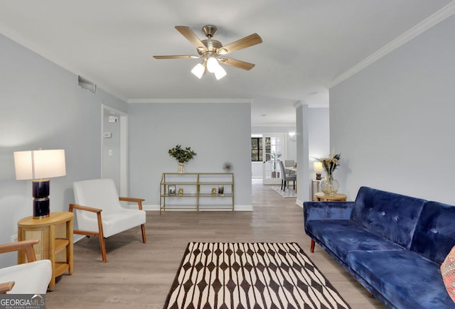 living room featuring hardwood / wood-style flooring, crown molding, and ceiling fan