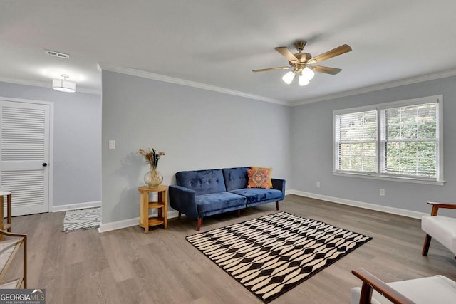 living room featuring hardwood / wood-style flooring, crown molding, and ceiling fan