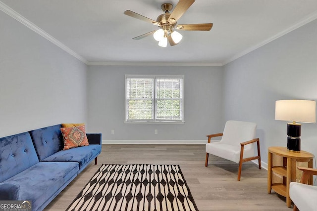 sitting room with wood-type flooring, ceiling fan, and ornamental molding