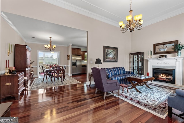 living room with ornamental molding, a notable chandelier, a premium fireplace, and wood finished floors