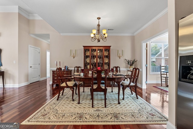 dining space featuring visible vents, an inviting chandelier, ornamental molding, wood finished floors, and baseboards