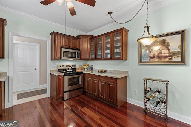 kitchen with stainless steel appliances, dark hardwood / wood-style flooring, ceiling fan, crown molding, and decorative light fixtures