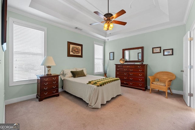 bedroom with light colored carpet, a raised ceiling, visible vents, and baseboards