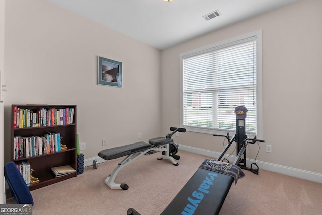 exercise room featuring carpet floors, visible vents, and baseboards