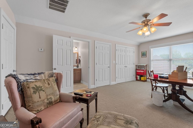 home office with baseboards, a ceiling fan, visible vents, and light colored carpet