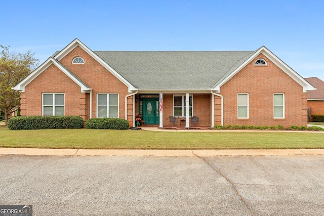 view of front of house with a front yard and brick siding