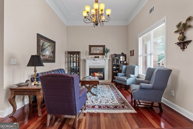 living room with ornamental molding, wood finished floors, a glass covered fireplace, and baseboards