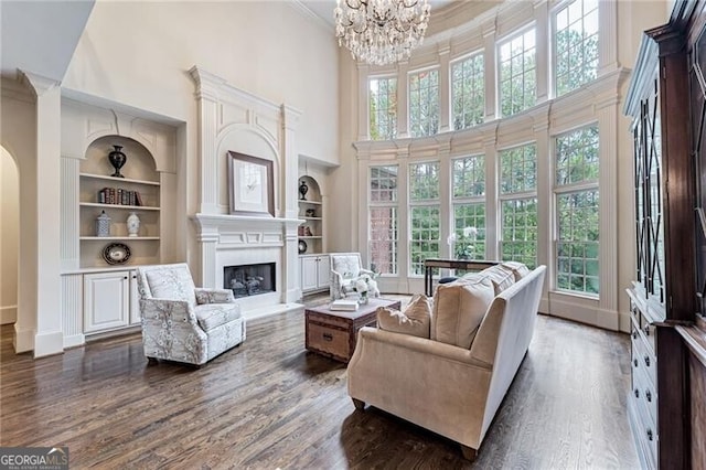 living room with a wealth of natural light, dark hardwood / wood-style floors, and a high ceiling