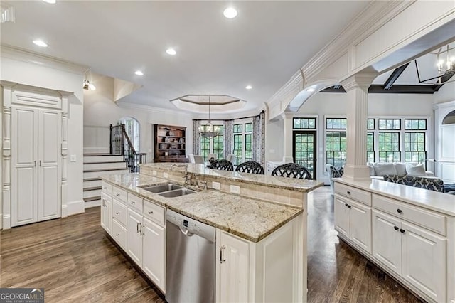 kitchen featuring an island with sink, plenty of natural light, dishwasher, and decorative columns