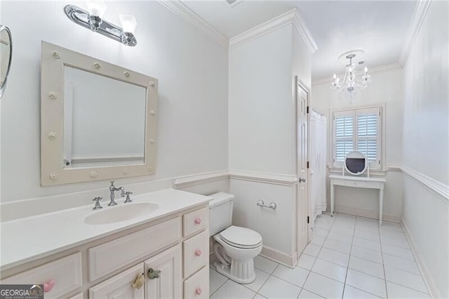 bathroom with tile patterned floors, ornamental molding, vanity, toilet, and a chandelier