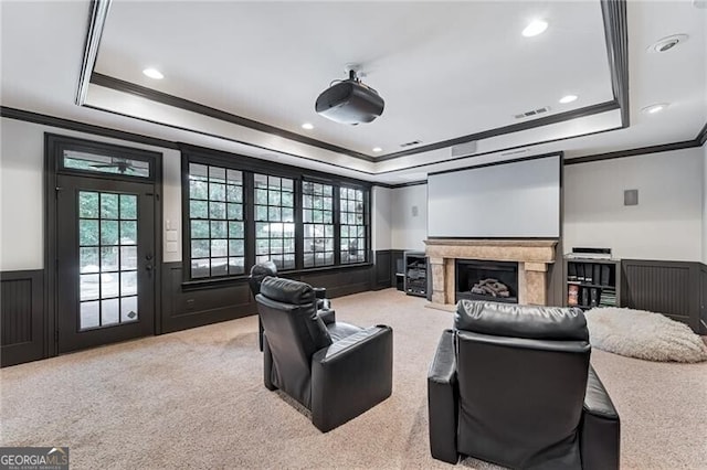 carpeted home theater room featuring a tray ceiling and crown molding