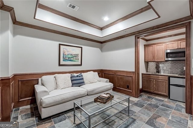 living room featuring ornamental molding and sink