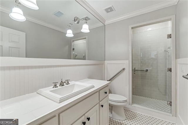 bathroom featuring toilet, a shower with shower door, vanity, and crown molding