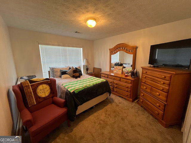 bedroom with a textured ceiling and carpet