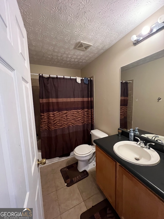 full bathroom with toilet, vanity, a textured ceiling, and tile patterned floors