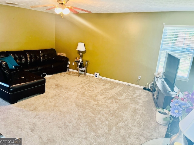 living room featuring a textured ceiling, ceiling fan, and carpet floors