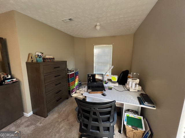 home office featuring a textured ceiling and light colored carpet