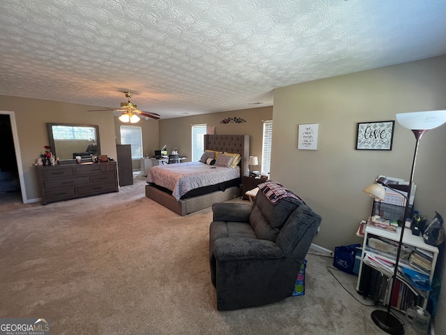 carpeted bedroom featuring a textured ceiling and ceiling fan