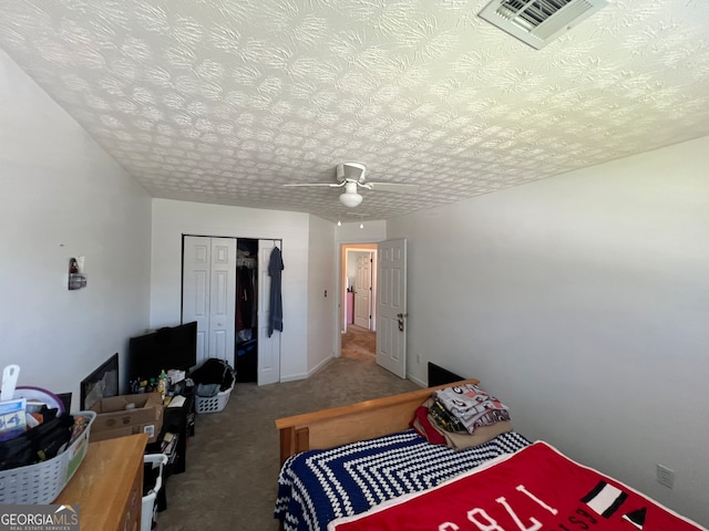 bedroom featuring ceiling fan, a textured ceiling, a closet, and carpet floors