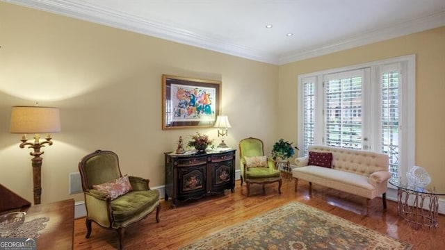 living area with ornamental molding and hardwood / wood-style floors