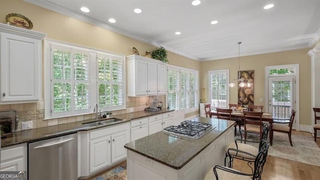 kitchen with white cabinetry, appliances with stainless steel finishes, and decorative light fixtures