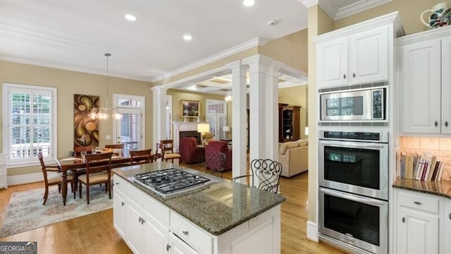 kitchen featuring white cabinetry, tasteful backsplash, stainless steel appliances, and dark stone counters