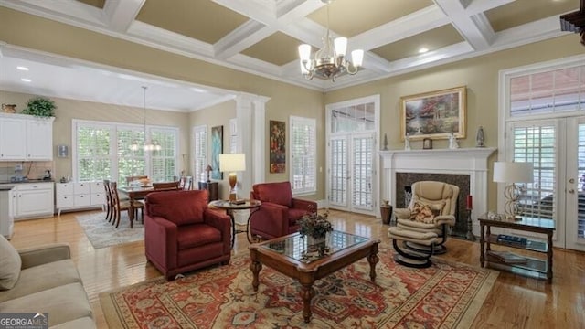 living room featuring a premium fireplace, ornamental molding, light wood-type flooring, and a wealth of natural light