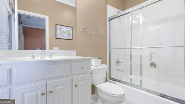 full bathroom with toilet, bath / shower combo with glass door, and vanity