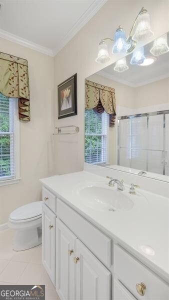 bathroom with toilet, vanity, plenty of natural light, and a shower with door