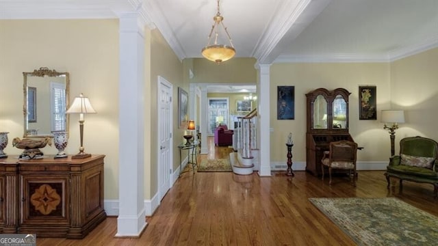 hall featuring ornate columns, hardwood / wood-style flooring, and ornamental molding