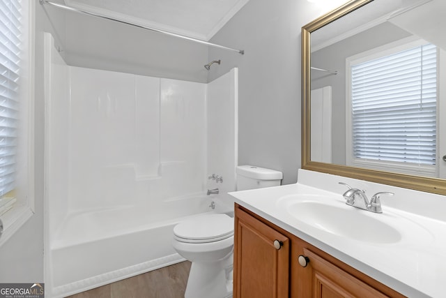 full bathroom with hardwood / wood-style flooring, toilet, ornamental molding, shower / washtub combination, and vanity