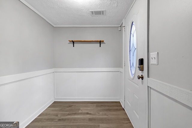 doorway with a textured ceiling and dark wood-type flooring