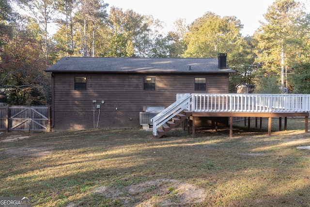 rear view of house with a wooden deck and a yard