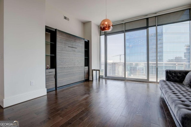 unfurnished living room featuring expansive windows and dark hardwood / wood-style floors