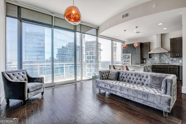 living room with plenty of natural light, dark hardwood / wood-style floors, and floor to ceiling windows