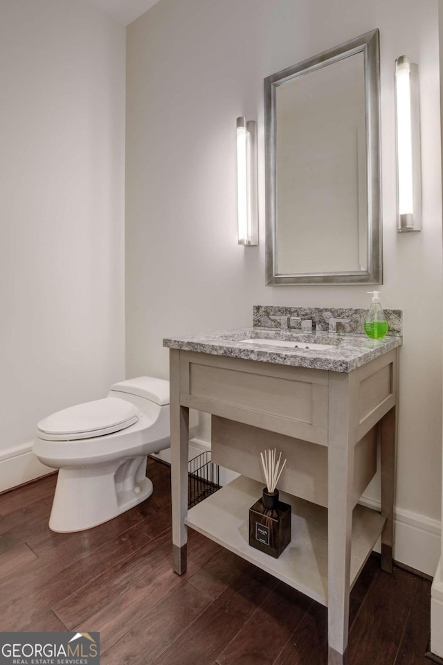 bathroom featuring vanity, toilet, and hardwood / wood-style flooring