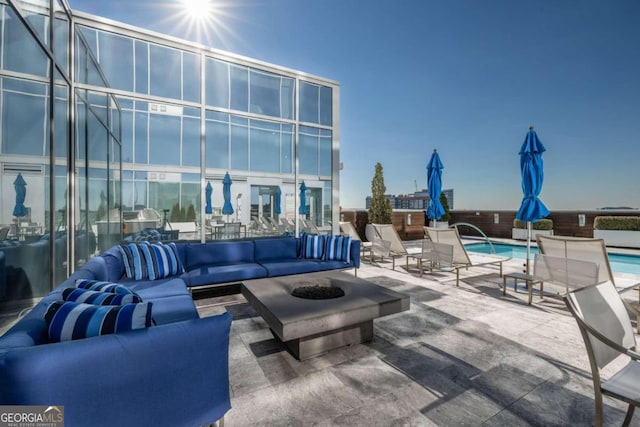 view of patio / terrace featuring a community pool and an outdoor living space with a fire pit