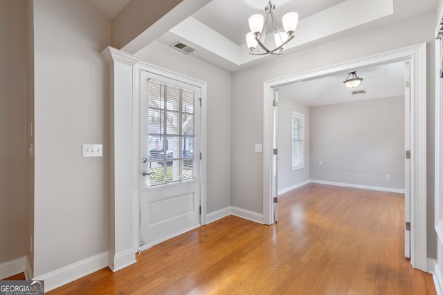 foyer with light wood-type flooring and a notable chandelier