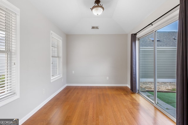 unfurnished room with light hardwood / wood-style flooring and lofted ceiling