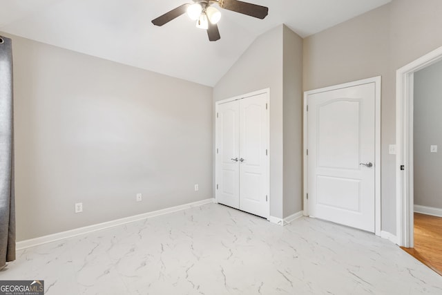 unfurnished bedroom featuring ceiling fan, a closet, light wood-type flooring, and vaulted ceiling